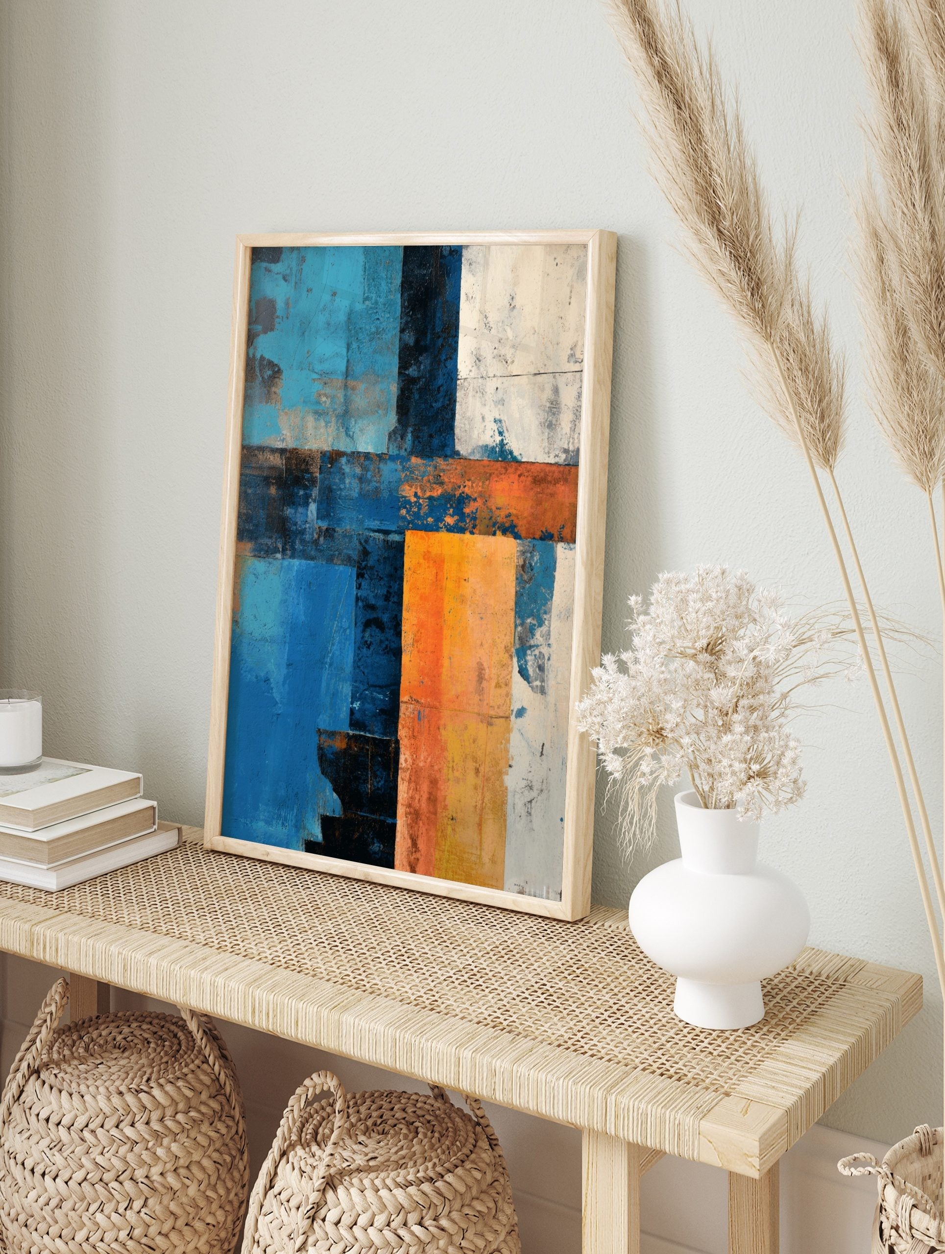 Abstract art print with textured blocks of blue, orange, white, and dark tones in a grid-like, in an alternate framed mockup