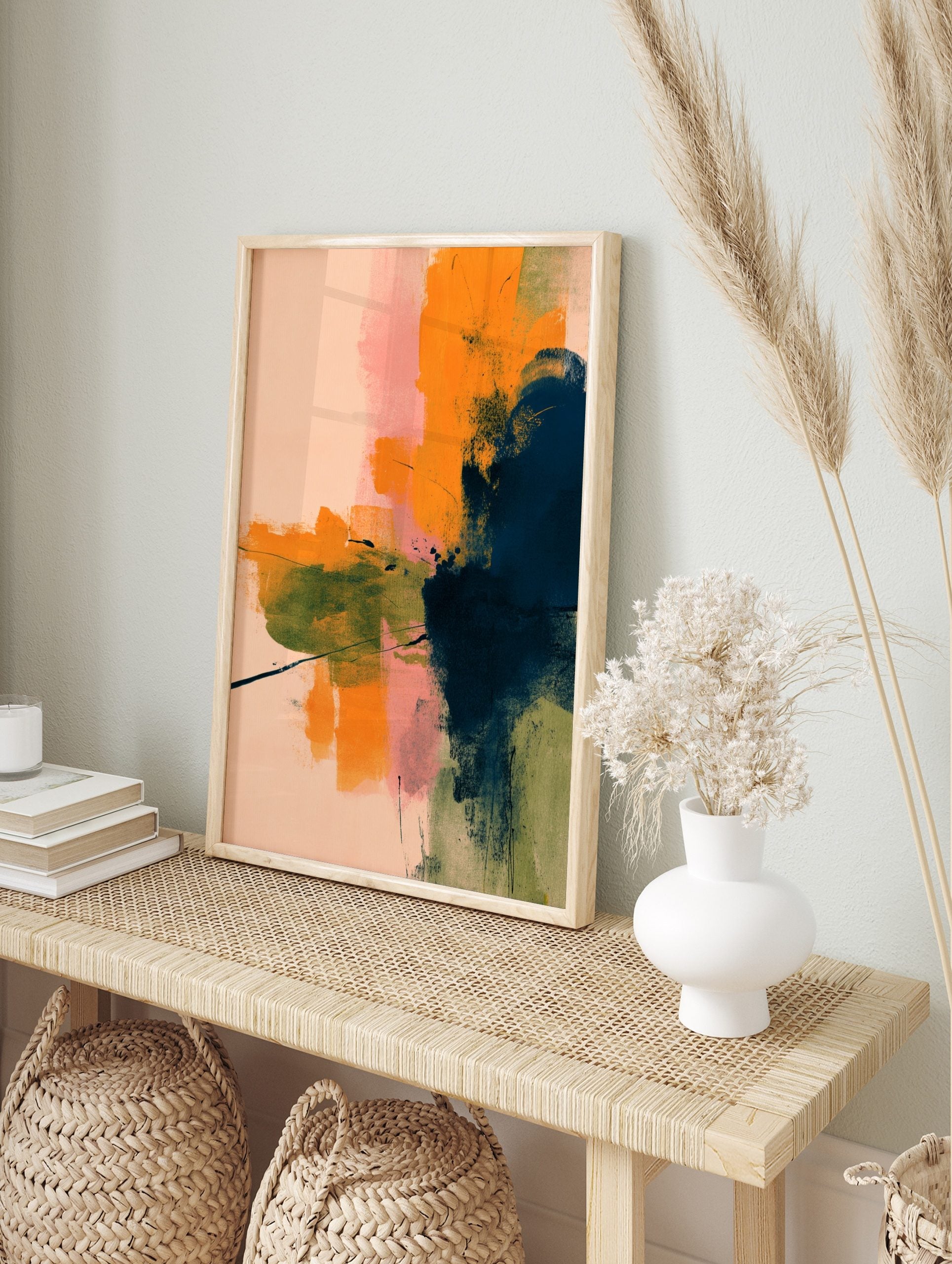 Abstract art print with layered brushstrokes in orange, navy blue, pink, and olive green on a, in an alternate framed mockup