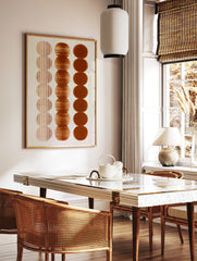 Abstract wall art print with three vertical columns of brown circles featuring vertical lines, in a styled room mockup