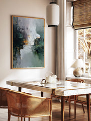 Textured abstract art print with dark green, grey, white, and orange, suggesting a reflective, in a styled room mockup