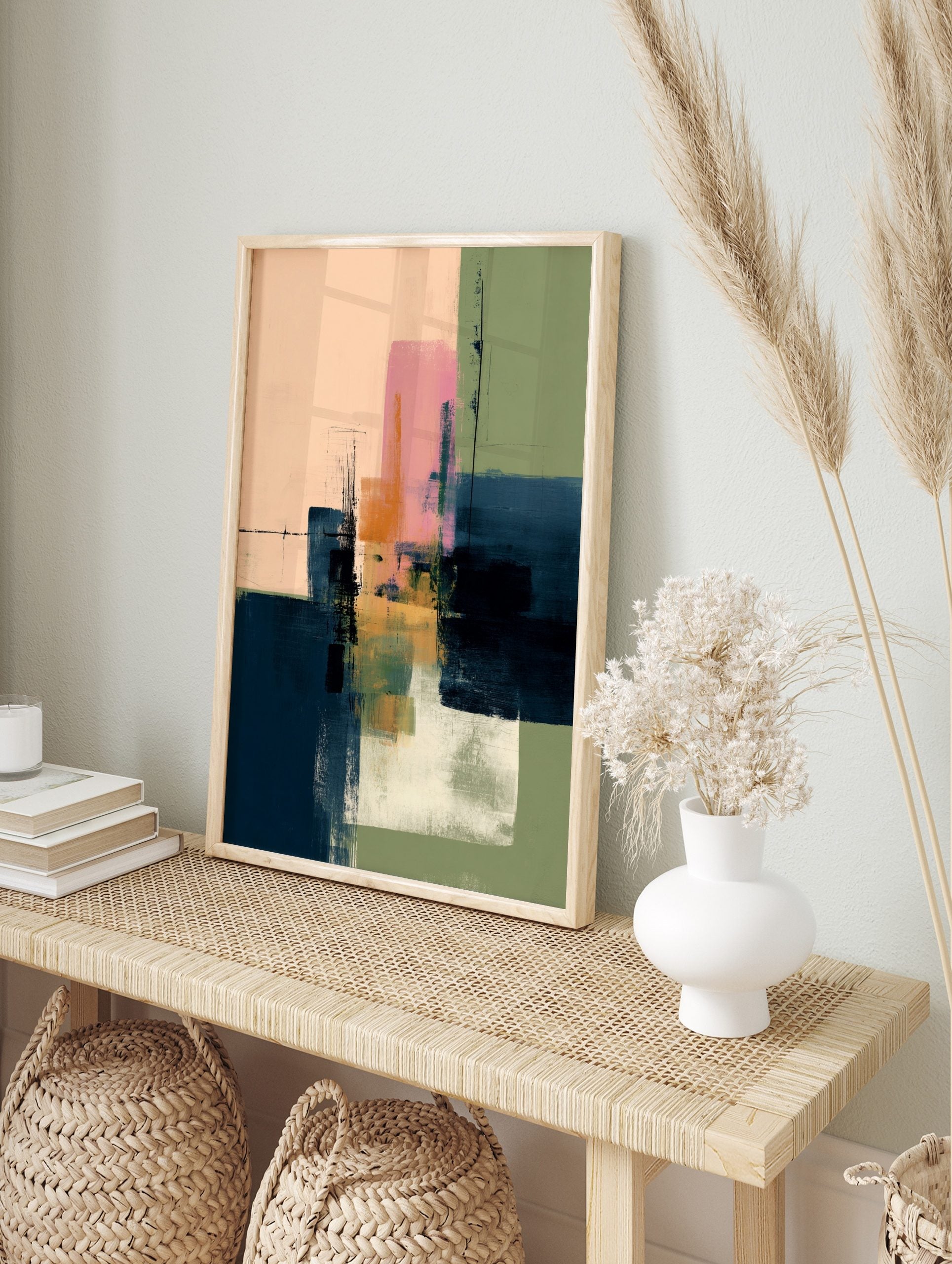 Abstract art print with layered blocks of pink, navy blue, green, and orange with visible, in an alternate framed mockup