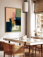 Abstract art print with layered blocks of pink, navy blue, green, and orange with visible, in a styled room mockup