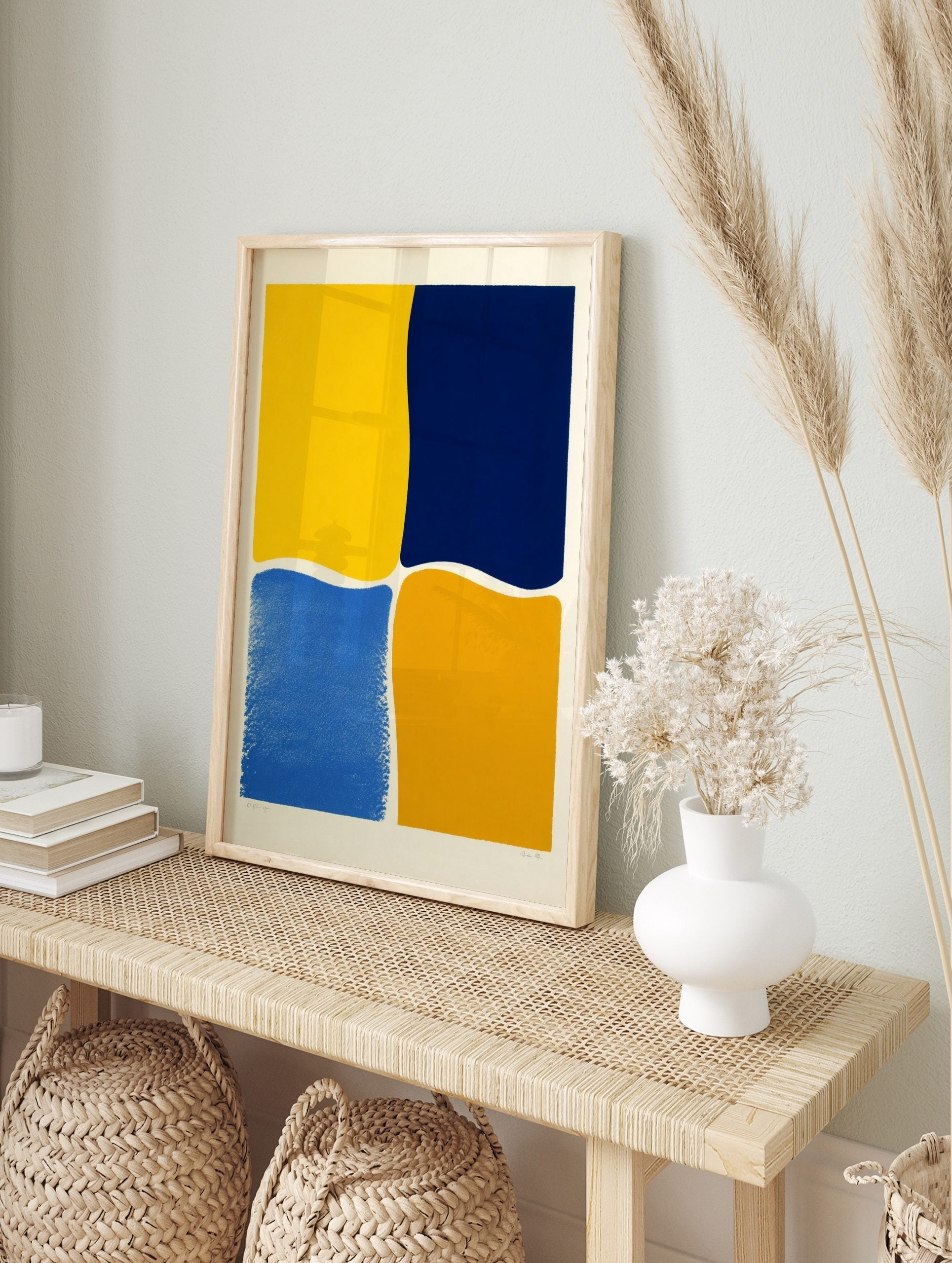 Abstract wall art with four irregular colour blocks in bright yellow, navy blue, medium blue, in an alternate framed mockup