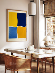 Abstract wall art with four irregular colour blocks in bright yellow, navy blue, medium blue, and, in a styled room mockup