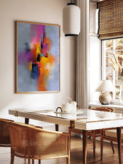 Abstract art print with vibrant pink, orange, yellow, and purple paint splashes on a grey, in a styled room mockup