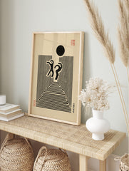 Abstract black figures dancing above concentric lines with a black circle and Japanese text, in an alternate framed mockup