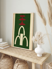 Abstract wall art with red tiered shapes and a white arched fountain motif on a green, in an alternate framed mockup