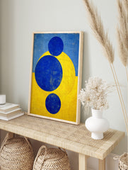 Abstract geometric art print with three blue circles and a yellow arc against a split blue, in an alternate framed mockup