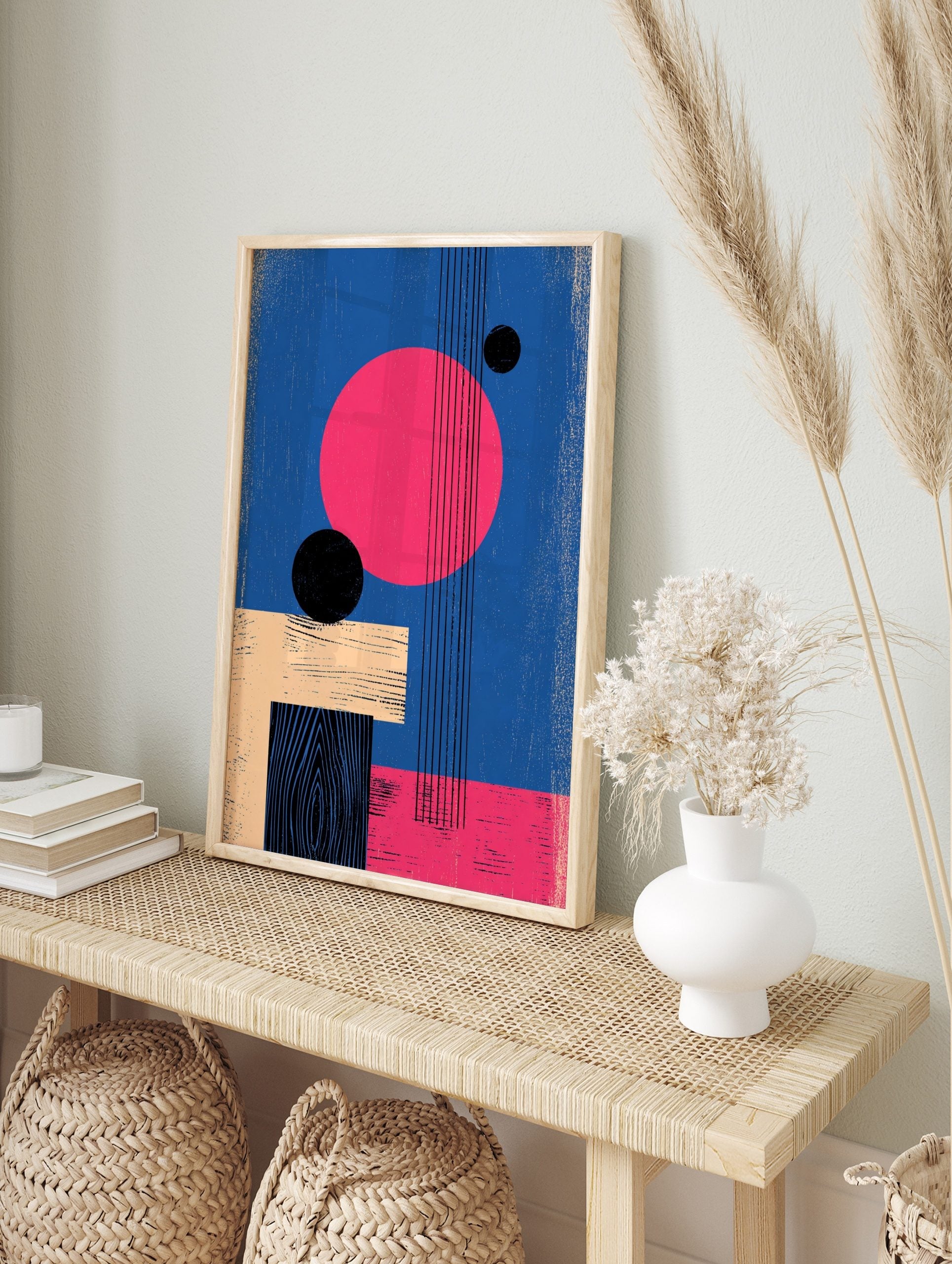 Abstract geometric wall art with large pink circle, black spheres, beige and black rectangles, in an alternate framed mockup