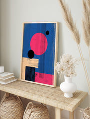 Abstract geometric wall art with large pink circle, black spheres, beige and black rectangles, in an alternate framed mockup