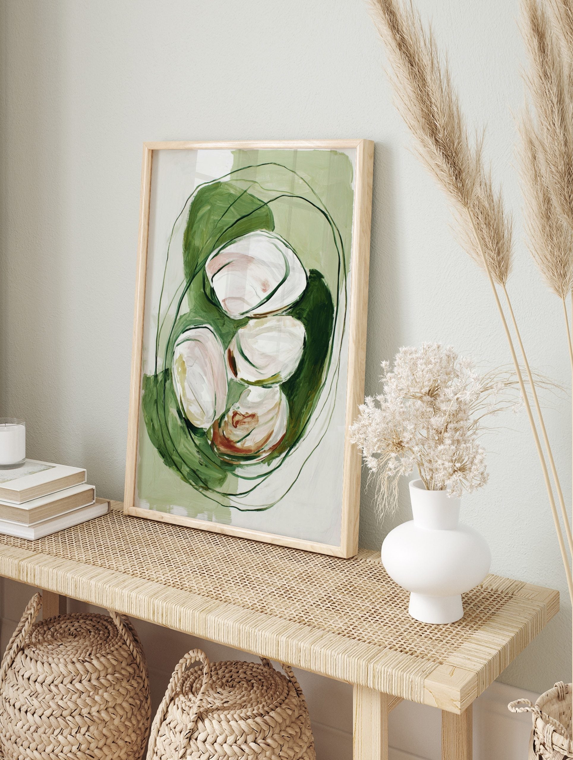 Abstract painterly art print with white and blush organic shapes nestled in green, in an alternate framed mockup
