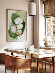 Abstract painterly art print with white and blush organic shapes nestled in green brushstrokes and, in a styled room mockup