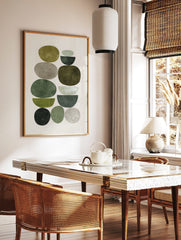 Abstract art print with stacked organic and semi-circular shapes in green and grey earth tones, in a styled room mockup