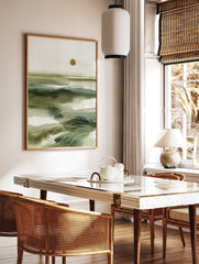 Abstract green seascape wall art with layered washes, white wavy lines, and a golden sun on, in a styled room mockup