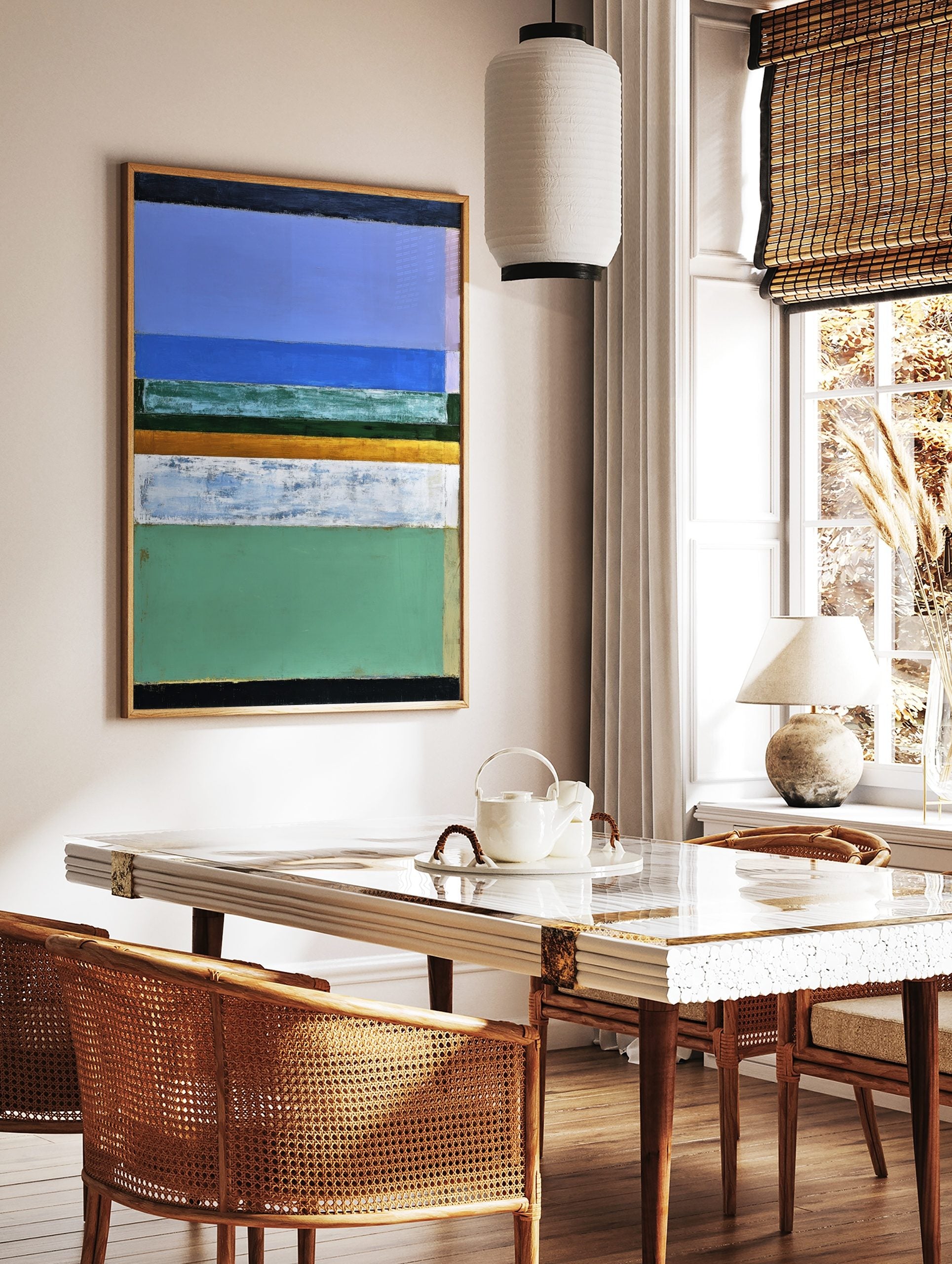 Abstract painting with horizontal bands of blue, green, gold, and white, evoking a serene landscape, in a styled room mockup