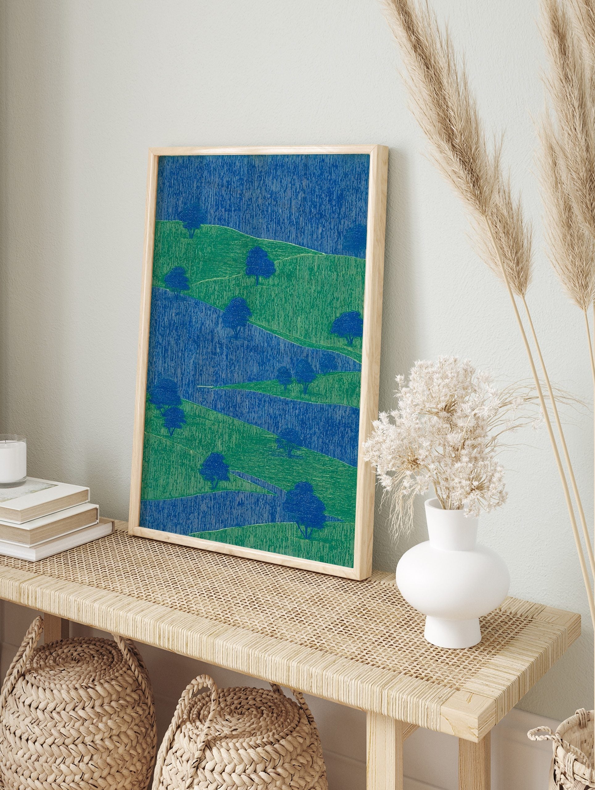 Abstract landscape art print with layered blue and green hills, stylised trees, and vertical, in an alternate framed mockup