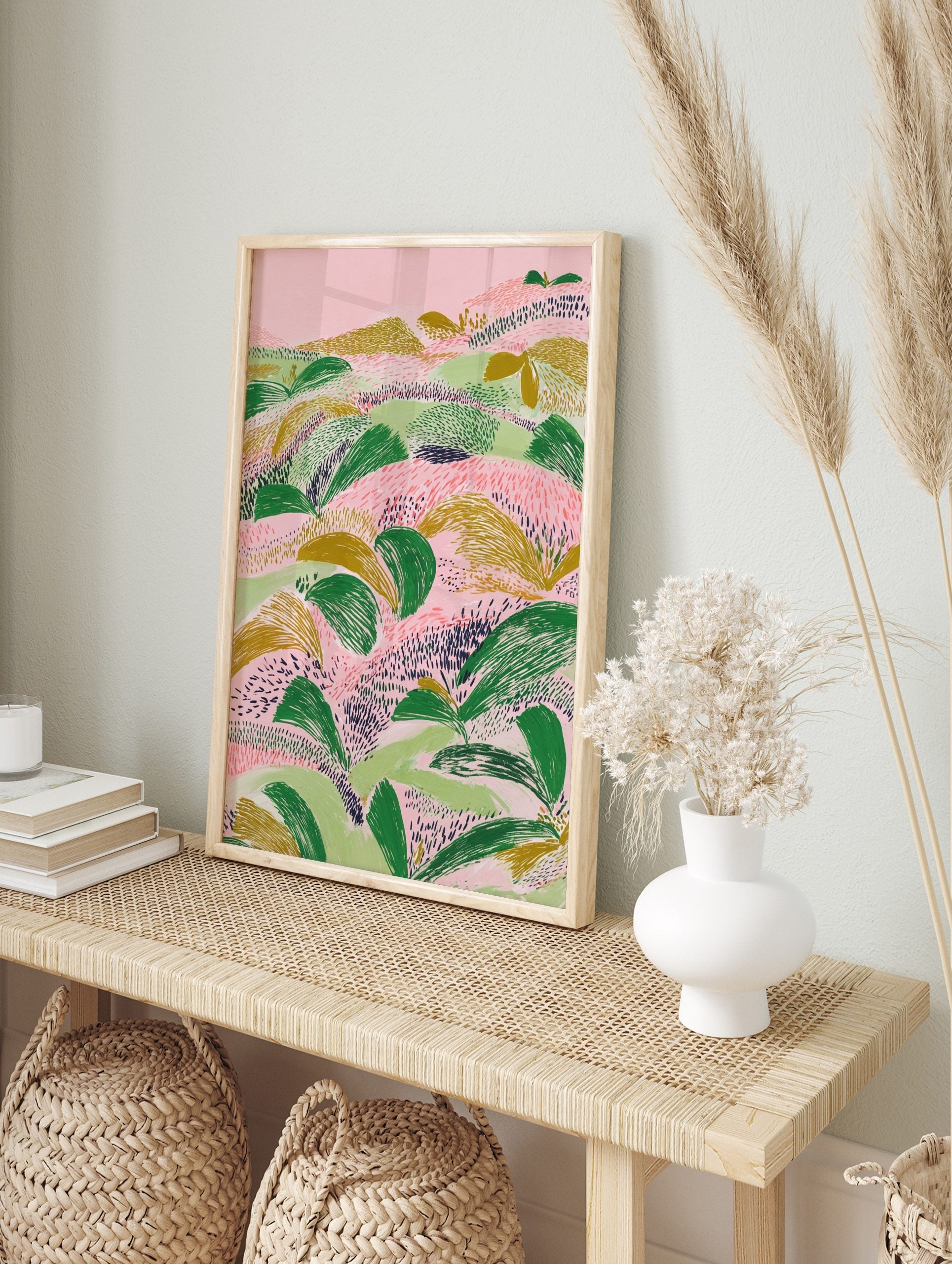 Abstract landscape illustration with textured green and gold foliage on a pink background, in an alternate framed mockup