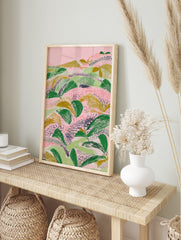 Abstract landscape illustration with textured green and gold foliage on a pink background, in an alternate framed mockup