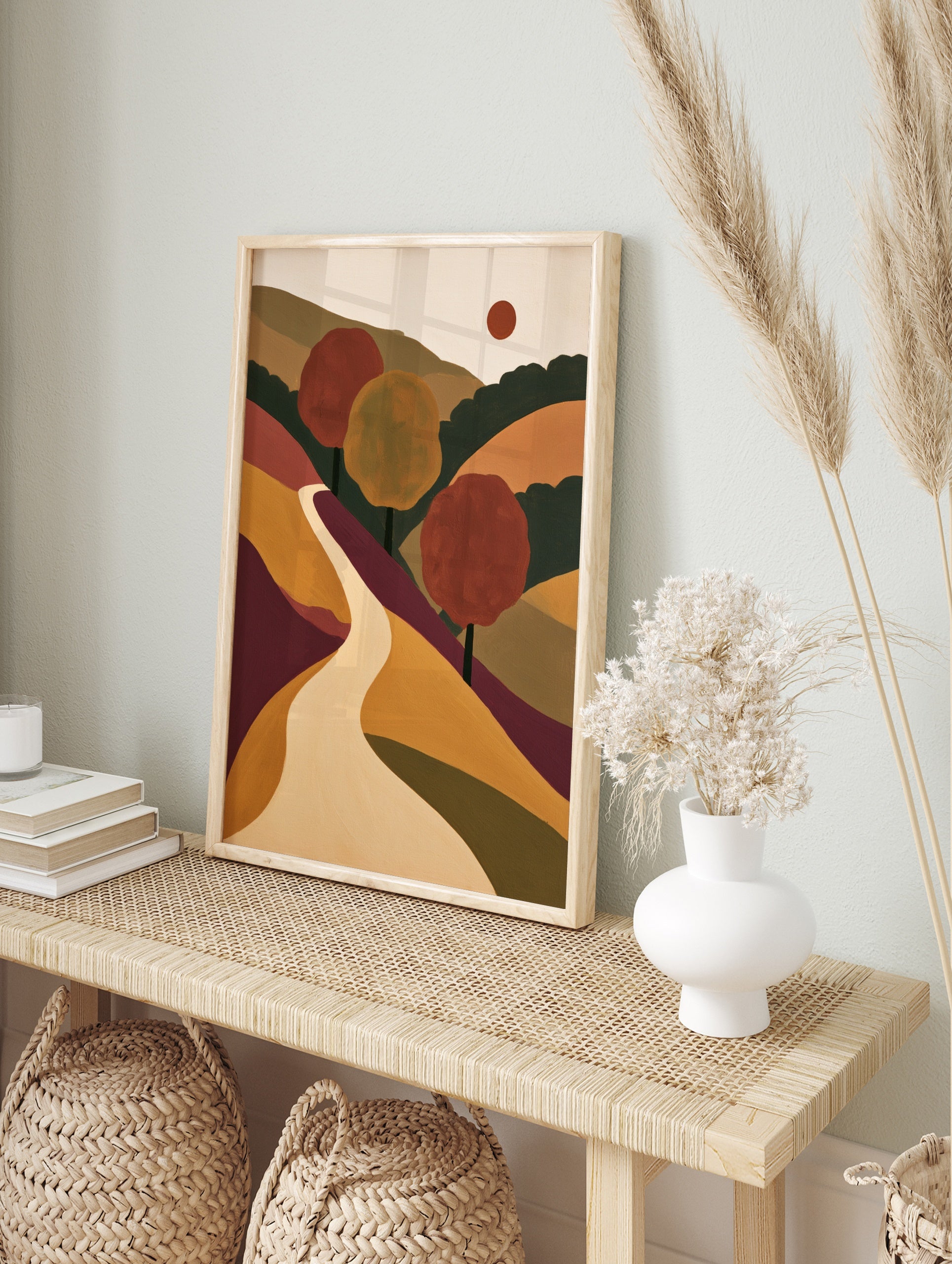 Abstract landscape wall art featuring a winding path through rolling hills, red and yellow, in an alternate framed mockup