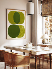 Abstract art print with overlapping olive green ovals and visible brushstrokes on white background, in a styled room mockup