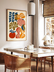 Abstract illustrative wall art with organic red, orange, and blue vegetable shapes on a cream, in a styled room mockup