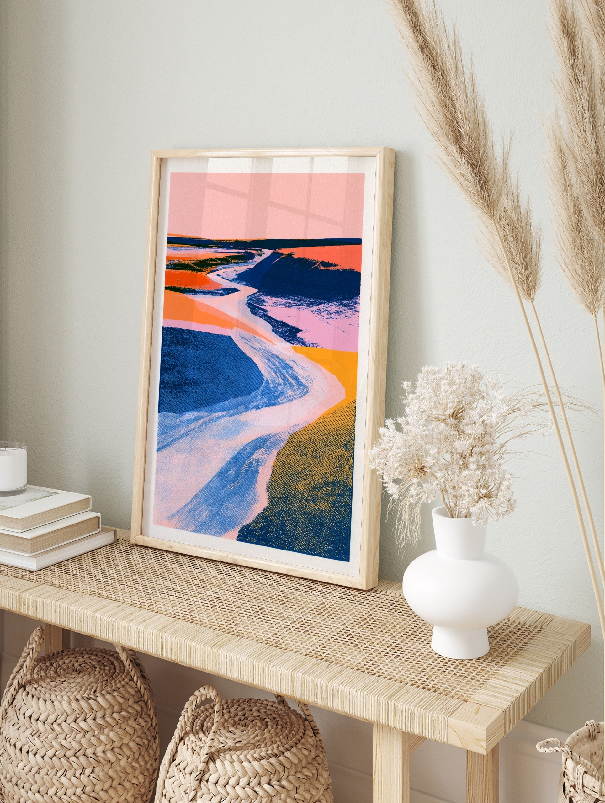 Abstract landscape wall art with a winding river, pink sky, and textured blue and orange, in an alternate framed mockup