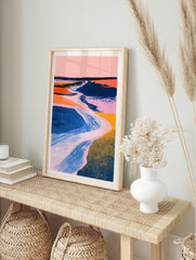 Abstract landscape wall art with a winding river, pink sky, and textured blue and orange, in an alternate framed mockup