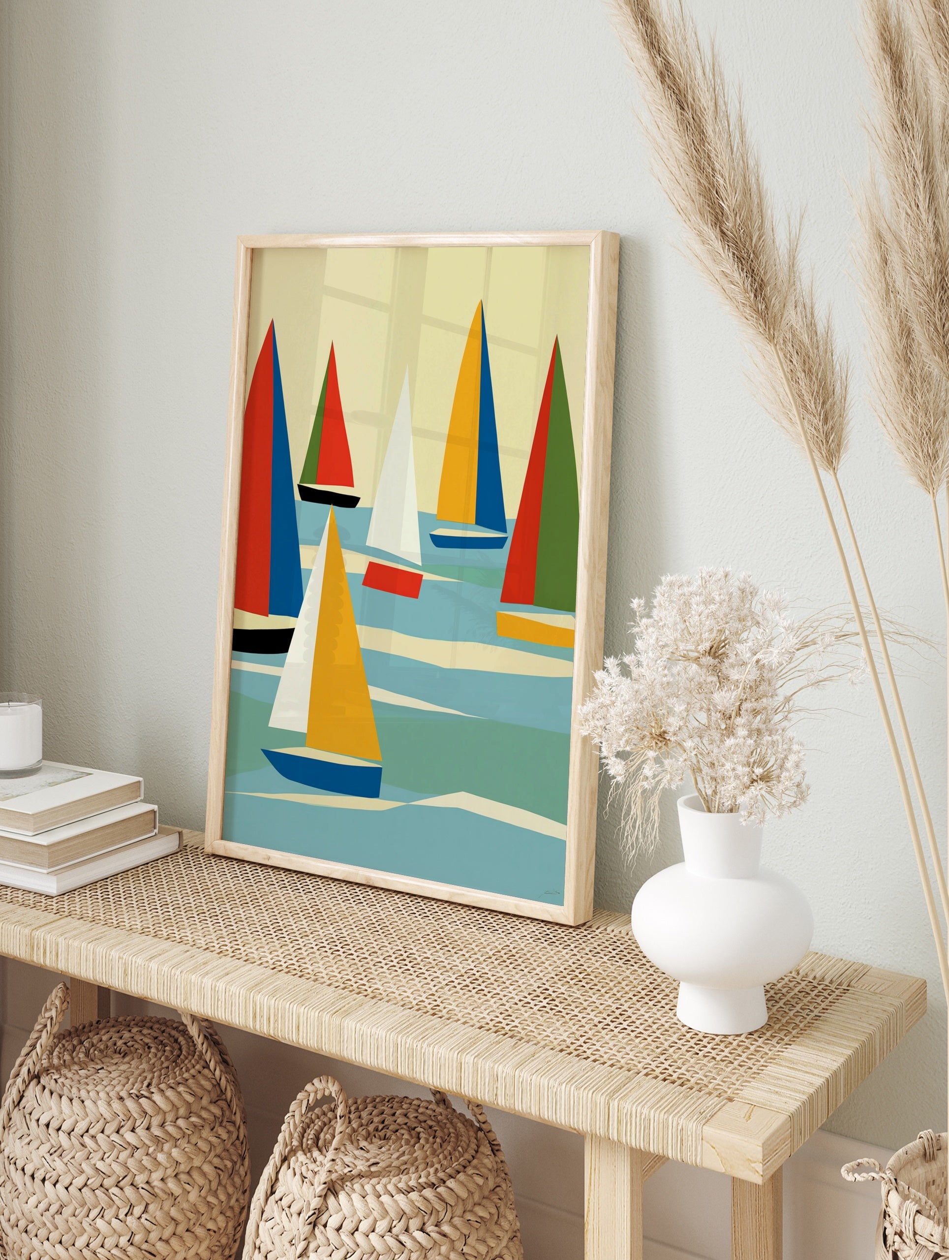 Abstract sailboat wall art with geometric red, blue, and yellow sails on a blue sea against a, in an alternate framed mockup