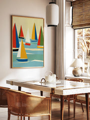 Abstract sailboat wall art with geometric red, blue, and yellow sails on a blue sea against a cream, in a styled room mockup