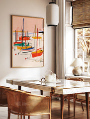 Abstract sailboat art print with red, yellow, and teal boats on a pink background, illustrative, in a styled room mockup