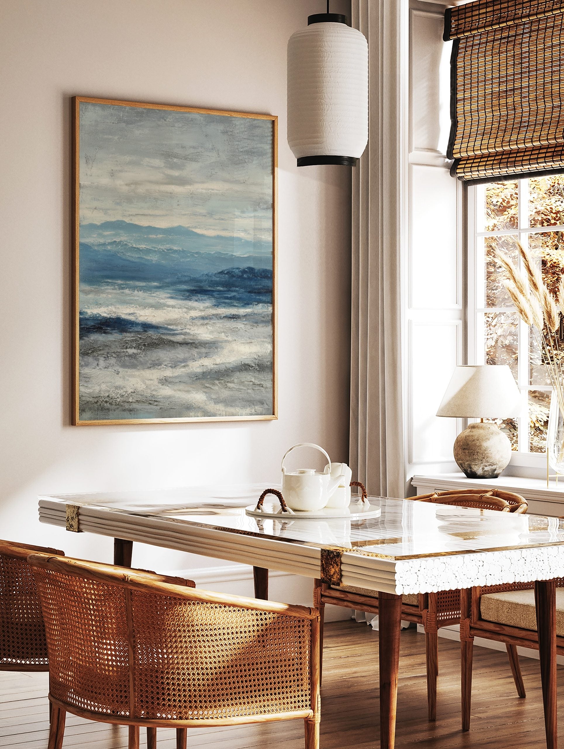 Abstract seascape painting with blue mountains, deep blue ocean, and textured white waves under a, in a styled room mockup