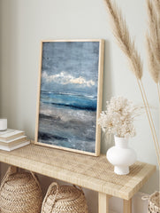 Textured abstract seascape painting with blue ocean, grey sky, and sandy beach in painterly, in an alternate framed mockup