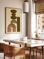 Abstract geometric art print with stacked brown ovals, concentric arches, and a vertical rectangle, in a styled room mockup