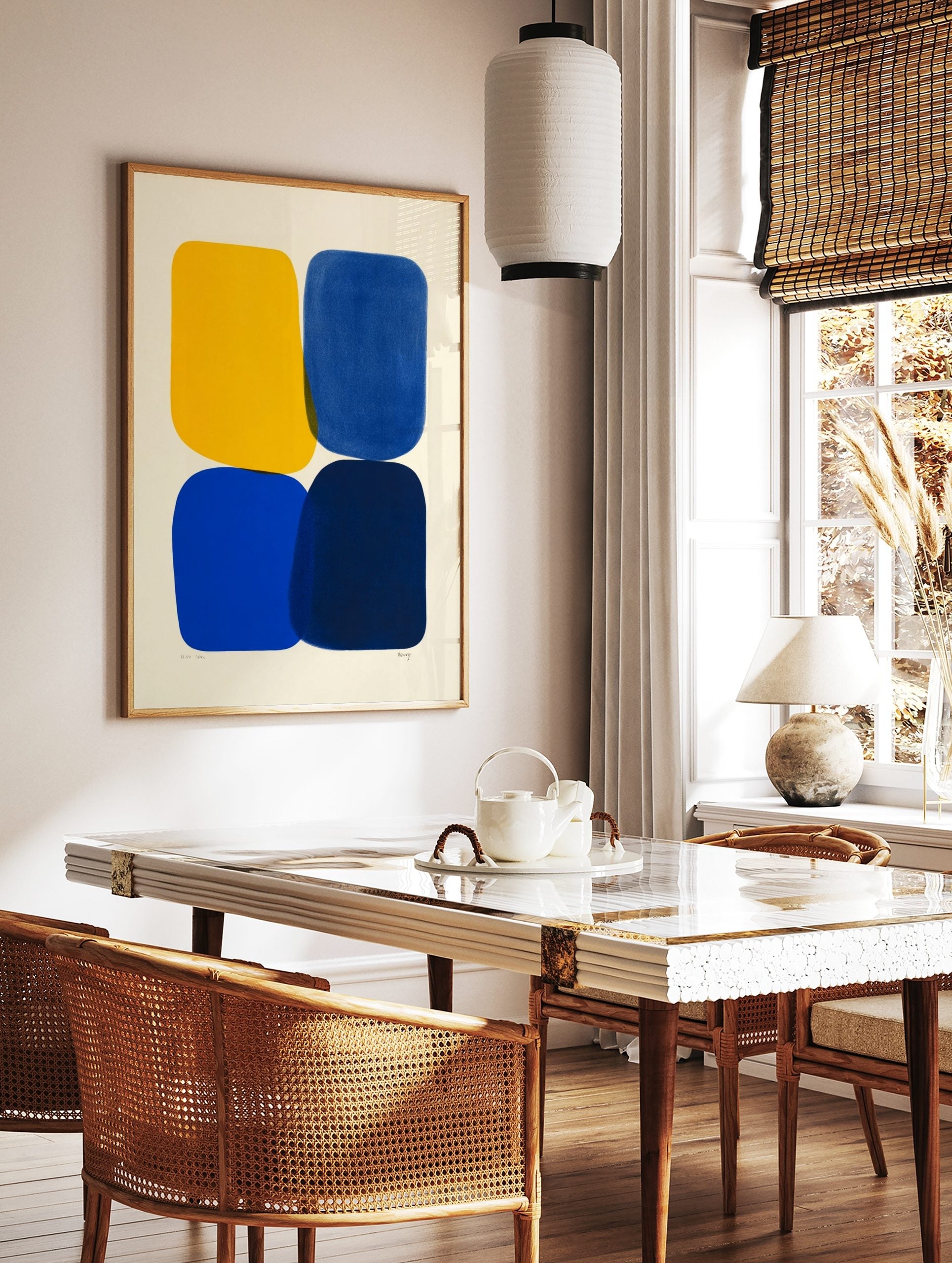 Abstract art print with four rounded shapes in yellow, blue, and navy on an off-white background, in a styled room mockup