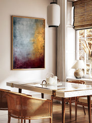 Abstract painting with textured silver, gold, and deep red colour fields blending vertically and, in a styled room mockup