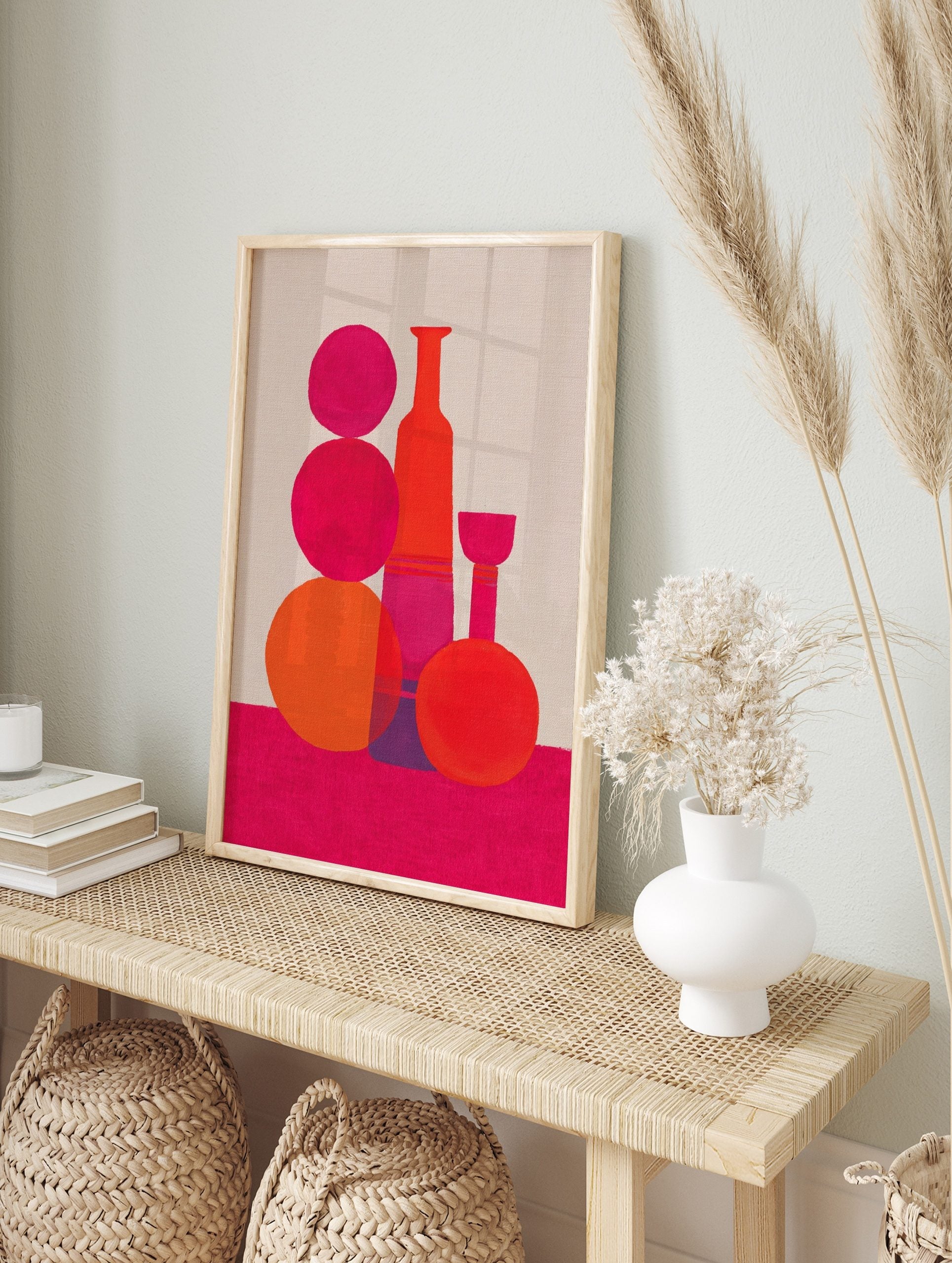 Abstract still life art print with pink and orange geometric bottle and sphere shapes on a, in an alternate framed mockup