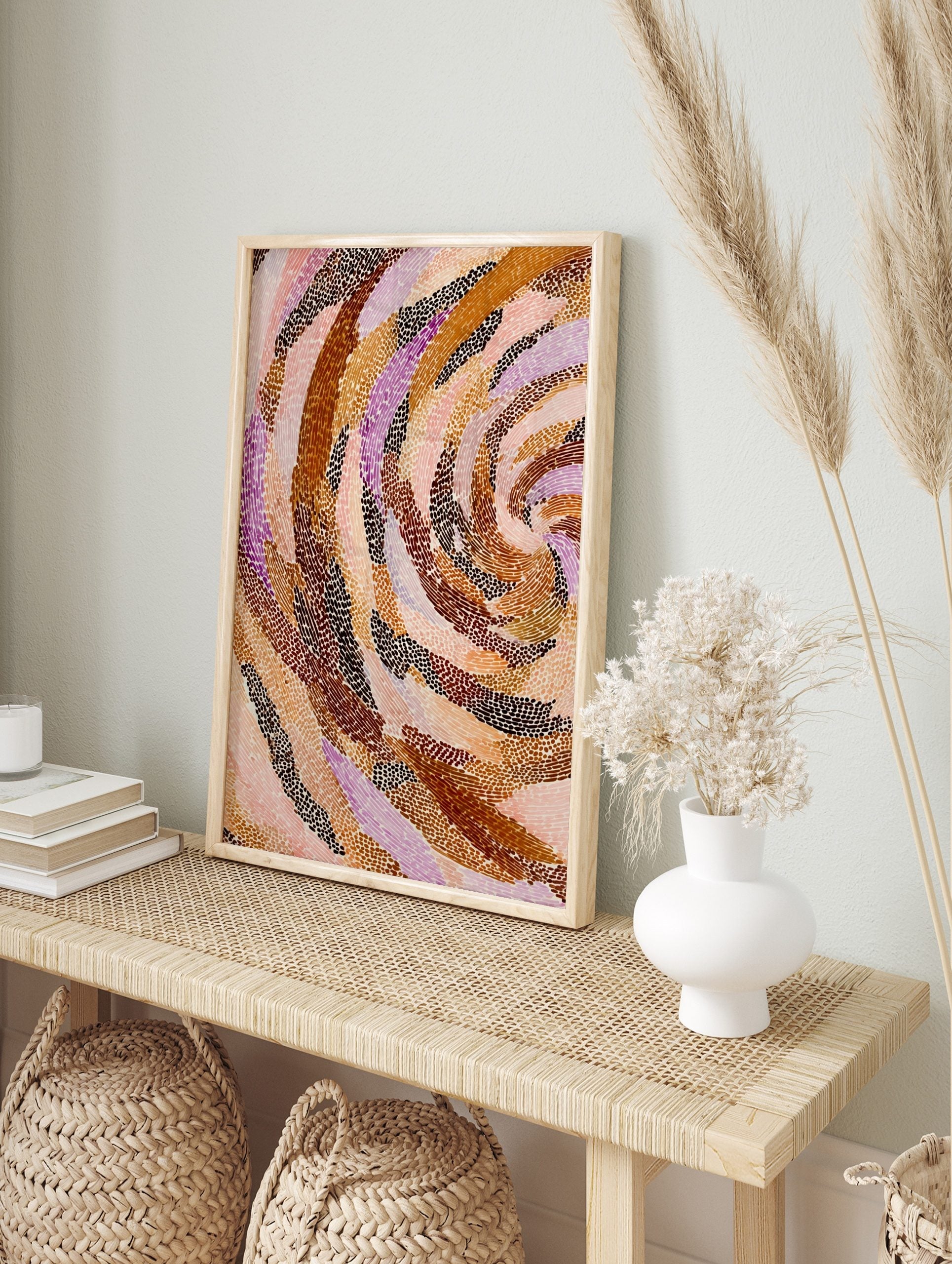 Abstract art print with swirling bands of brown, orange, pink, and purple dots on a light, in an alternate framed mockup