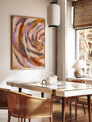 Abstract art print with swirling bands of brown, orange, pink, and purple dots on a light background, in a styled room mockup