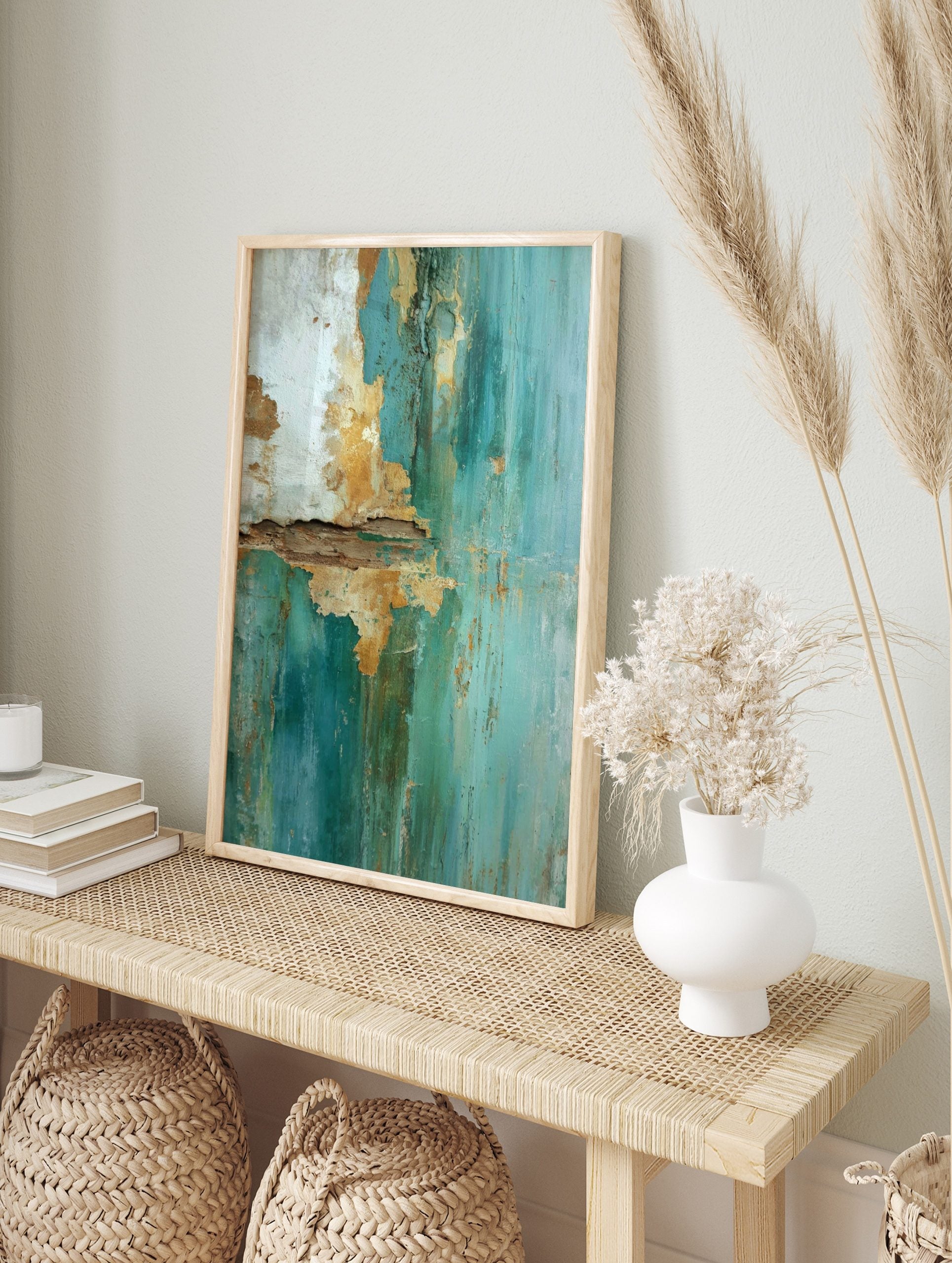 Close-up of peeling teal and gold paint on a textured wall surface with cracks and rough edges, in an alternate framed mockup
