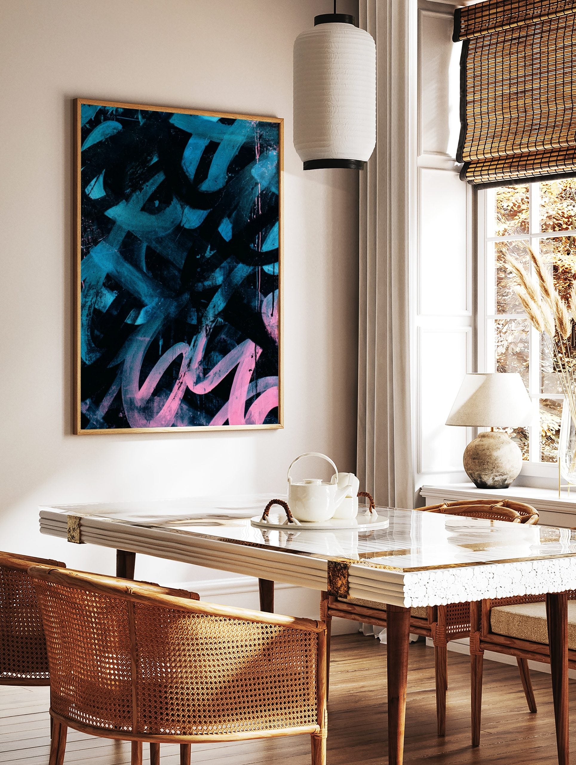 Abstract art print with bold teal and pink brushstrokes and splatters on a black background, in a, in a styled room mockup