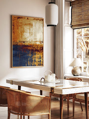 Abstract wall art with golden orange, deep blue, and cream distressed textures in a vertical, in a styled room mockup