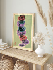 Abstract wall art with stacked red, purple, and blue circular shapes on a muted green, in an alternate framed mockup