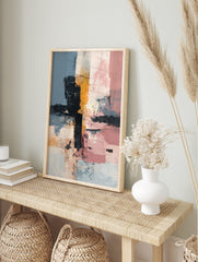 Abstract wall art with textured blocks of muted blue, black, mustard yellow, and pink, in an alternate framed mockup