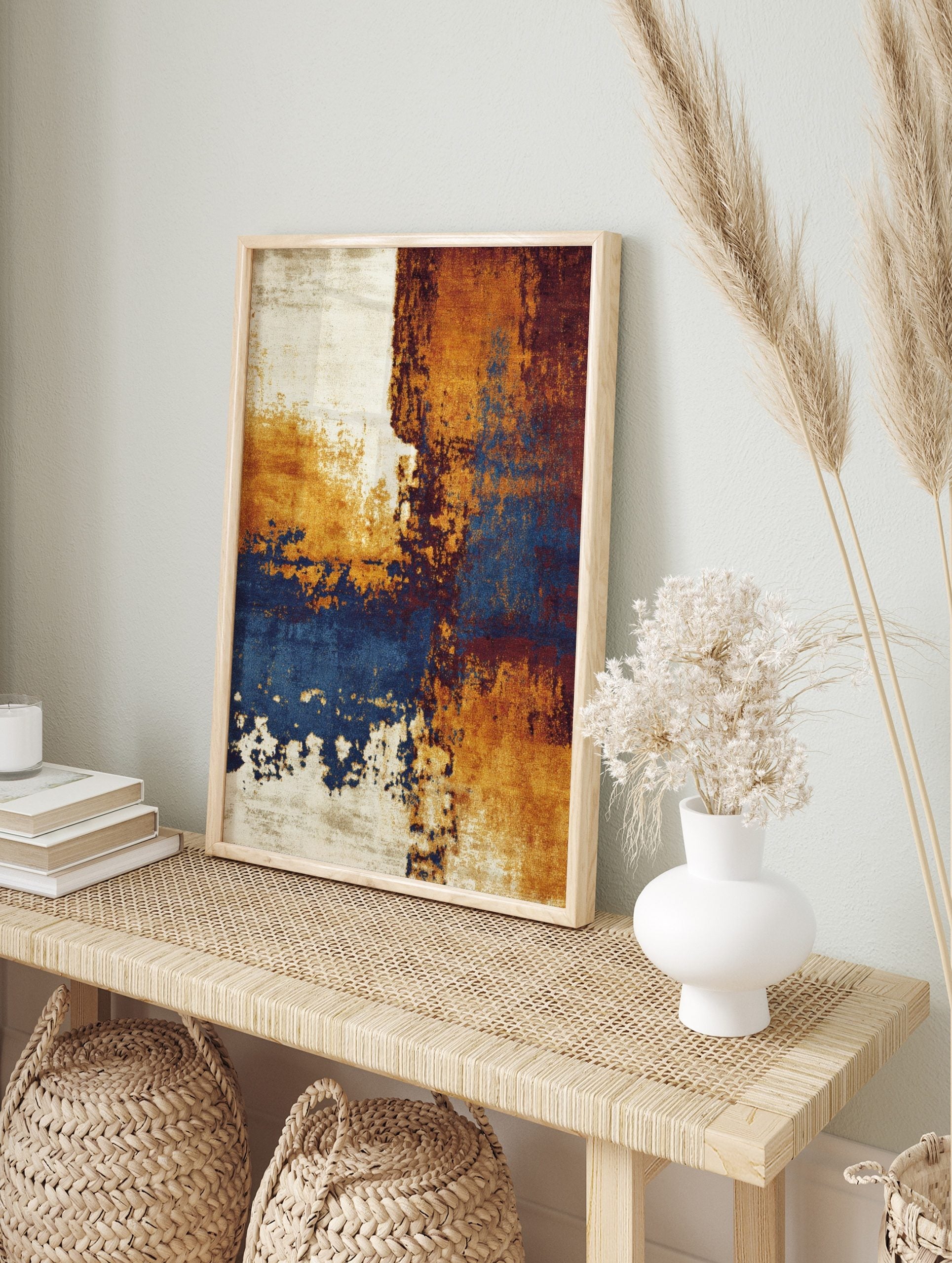 Abstract wall art print with distressed textures in ochre, deep blue, reddish-brown, and, in an alternate framed mockup