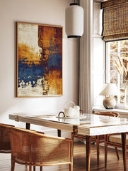 Abstract wall art print with distressed textures in ochre, deep blue, reddish-brown, and off-white, in a styled room mockup