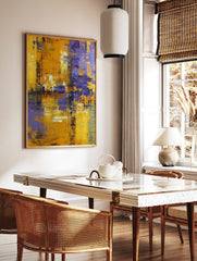 Abstract painting with textured yellow and purple brushstrokes creating a modern, distressed art, in a styled room mockup