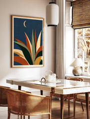 Abstract agave plant illustration with orange and green leaves against a dark blue sky with a, in a styled room mockup