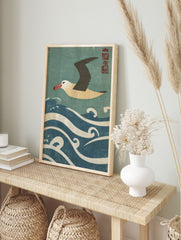 Japanese style albatross flying over blue and white waves with red kanji seal in the corner, in an alternate framed mockup