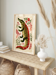 Illustrative green alligator with red patterned scales and red eyes, surrounded by green, in an alternate framed mockup