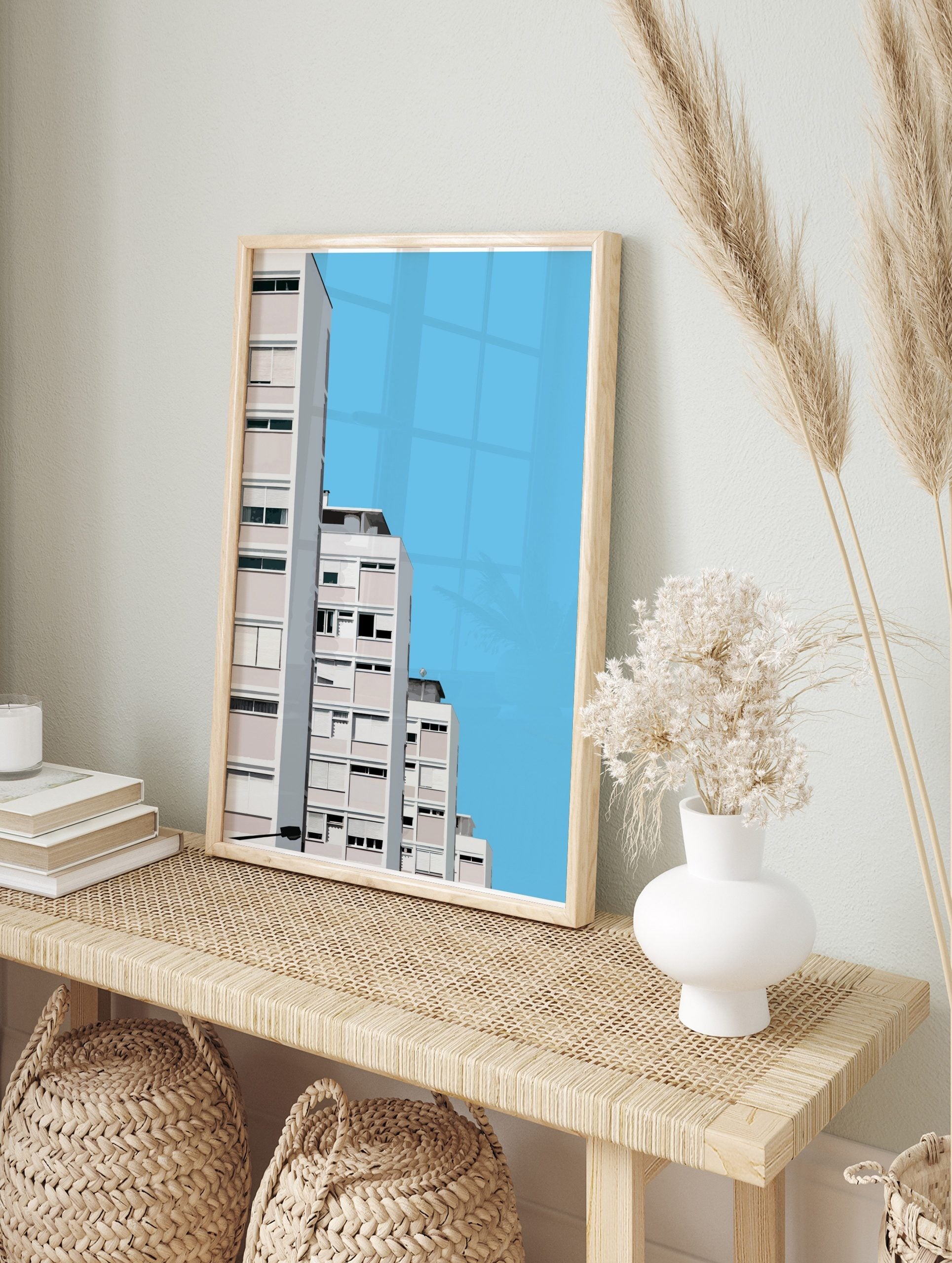 Minimalist architectural wall art of modern white and pink apartment buildings against a clear blue sky, displayed as the same artwork in an alternate framed wall art mockup